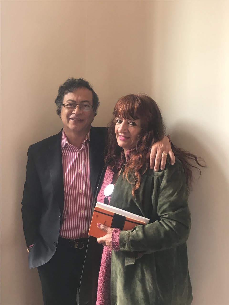 El presidente Gustavo Petro y la Fundadora en una foto de interior; la fundadora sostiene una libreta mientras abraza al presidente. ambos con postura amistosa.